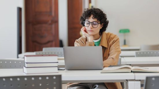 thoughtful-woman-in-library-watches-online-traini-2022-12-18-18-45-46-utc